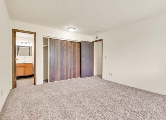 A room with a grey carpet and a wooden cabinet. at Winding Hills Apartments, Davenport , IA