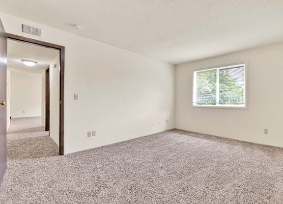 A room with a carpeted floor and a window. at Winding Hills Apartments, Davenport , IA, 52807