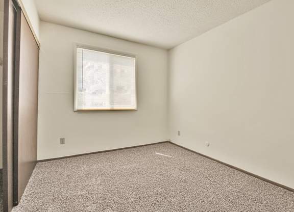 A room with a window and a picture frame on the wall. at Winding Hills Apartments, Iowa, 52807