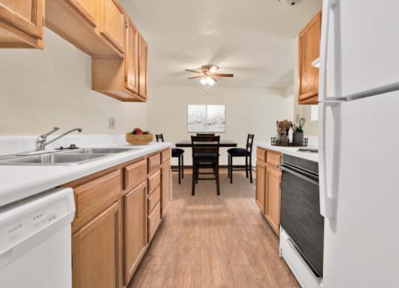 A kitchen with wooden cabinets and a white fridge. at Winding Hills Apartments, Iowa, 52807