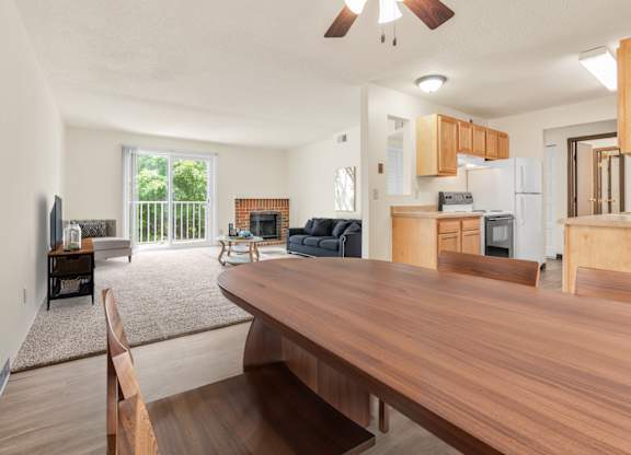 A modern kitchen with wooden cabinets and a dining table. at Winding Hills Apartments, Davenport