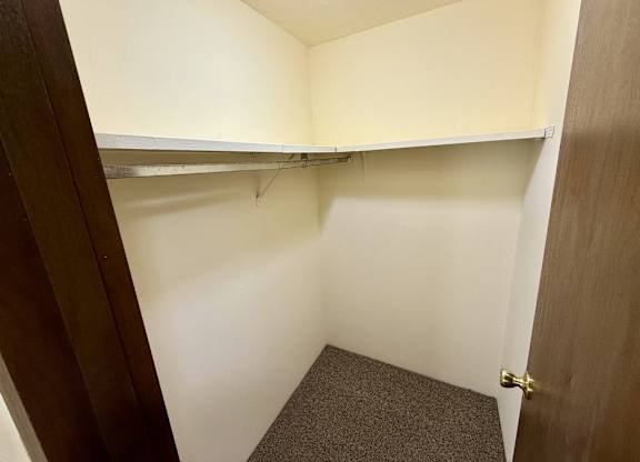 A small, empty room with a carpeted floor and a door on the right. at Winding Hills Apartments, Iowa, 52807