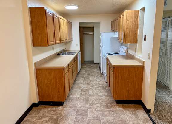 A kitchen with wooden cabinets and a tiled floor. at Winding Hills Apartments, Davenport , IA, 52807