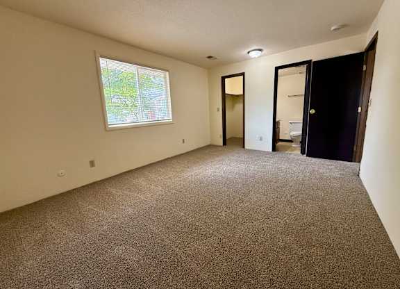 A room with a carpeted floor and a window. at Winding Hills Apartments, Davenport , IA, 52807