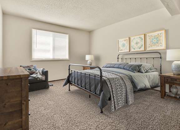 A bedroom with a bed, nightstand, and dresser. at Winding Hills Apartments, Davenport , IA