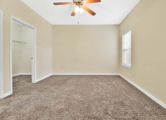 A room with a ceiling fan and carpeted floor. at Deer Valley Apartments, Silvis, IL, 61282