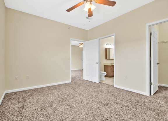 A room with a ceiling fan and carpeted floor. at Deer Valley Apartments, Silvis, IL, 61282