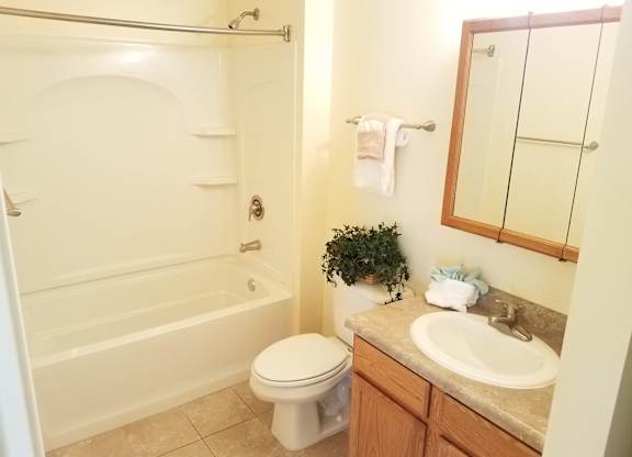 A bathroom with a toilet, sink, and bathtub.at Windsor Crest Apartments, Iowa