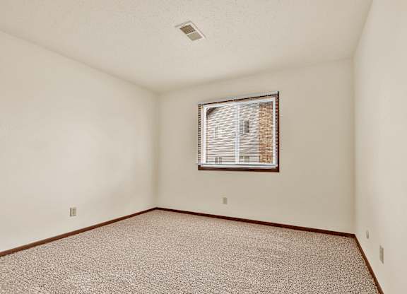 A room with a window and carpeted floor.at Windsor Crest Apartments, Davenport