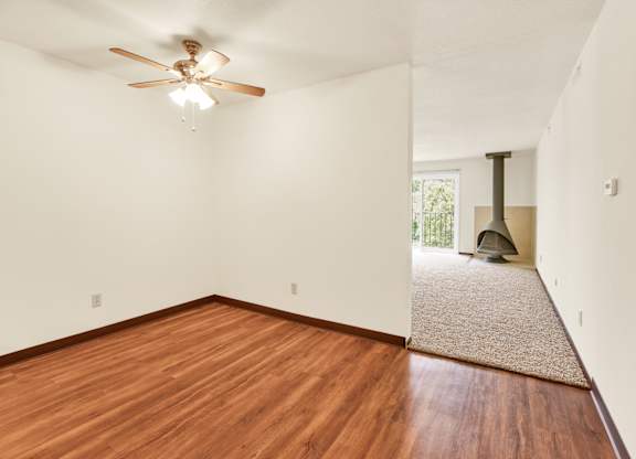 A room with a ceiling fan and wooden floors. at Indian Ridge Apartments, Davenport, 52807