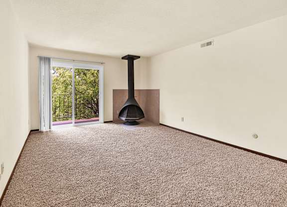 A room with a carpet floor and a fireplace. at Indian Ridge Apartments, Davenport, Iowa