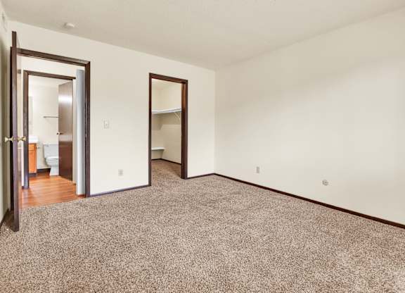 A room with a carpeted floor and two open doors. at Indian Ridge Apartments, Iowa, 52807