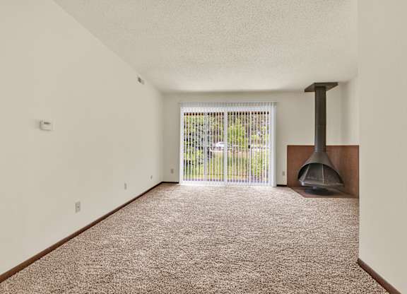 A room with a carpet floor and a fireplace. at Indian Ridge Apartments, Davenport, IA, 52807