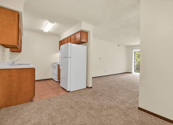 A kitchen area with a refrigerator and a counter. at Indian Ridge Apartments, Davenport, Iowa