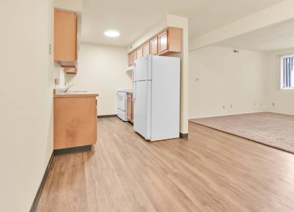 A kitchen with a white fridge and wooden floors. at Indian Ridge Apartments, Davenport, IA, 52807