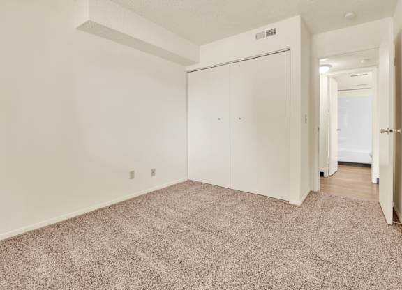 A room with a carpeted floor and a white door. at Indian Ridge Apartments, Davenport, IA