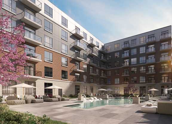 A modern apartment complex with a pool and outdoor seating area at The Woods at 180 Kanata Avenue, Kanata, Ontario