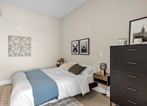 A bedroom with a white bed and a blue blanket.