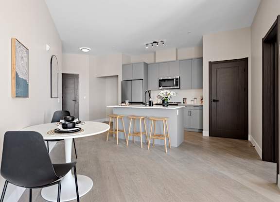 A modern kitchen with a dining table and chairs.