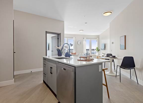 A kitchen with a refrigerator, oven, and sink.