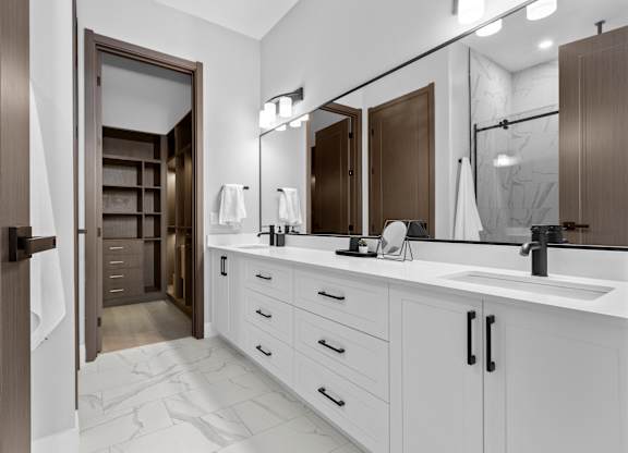 A bathroom with a white counter and a brown door.