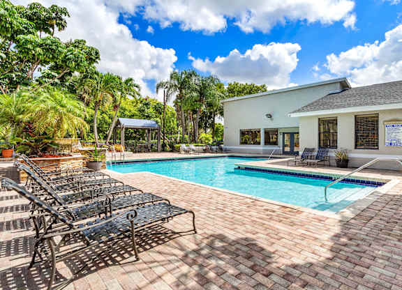 A pool with a black metal bench next to it.