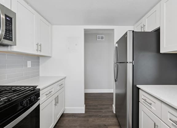 A kitchen with white cabinets and a black stove top oven.