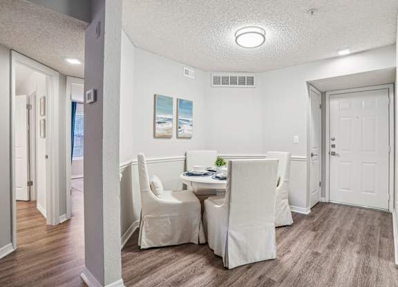 A dining room with a table and chairs.