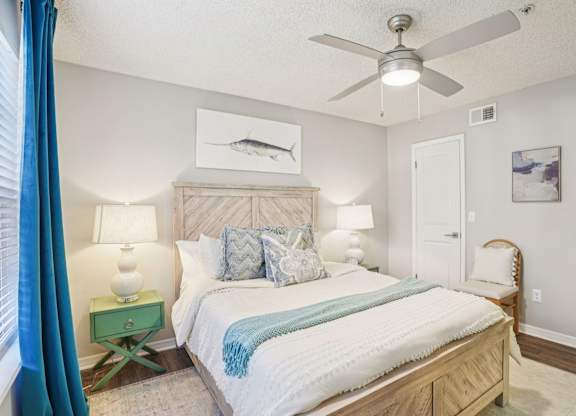 A bedroom with a bed, nightstand, and a ceiling fan.