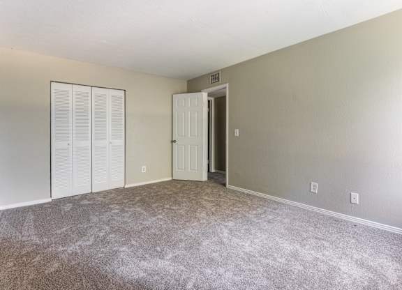 A room with a carpeted floor and a white door.