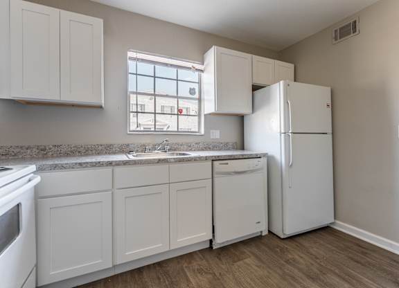 A kitchen with white appliances and cabinets.