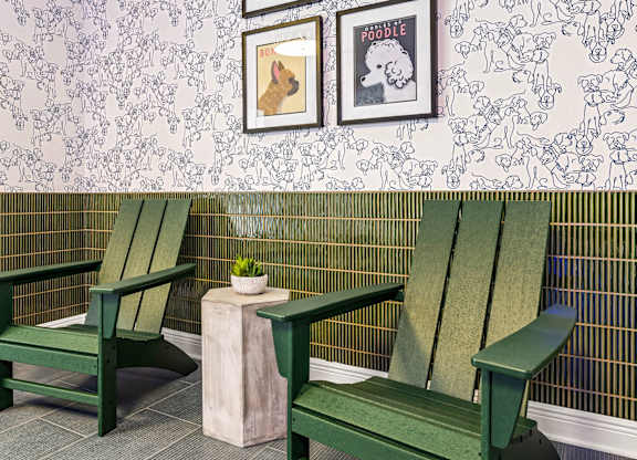 Two green chairs and a small table with a plant on it.