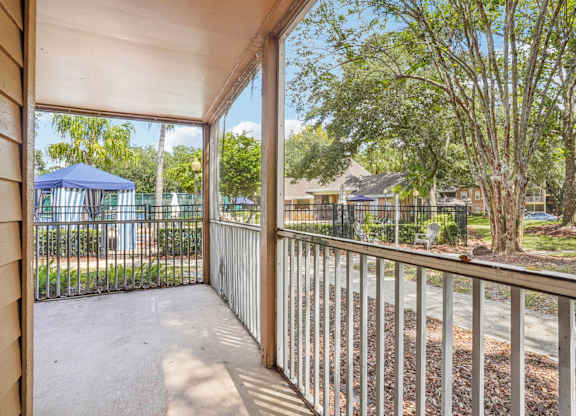 A view from a balcony looking out at a playground and houses.