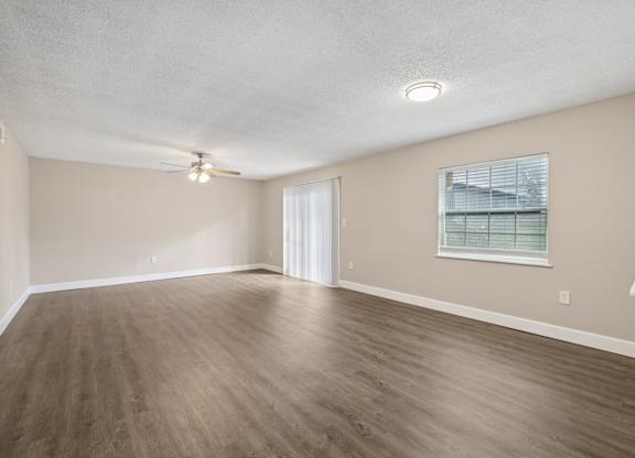 Empty room with wooden floor and white ceiling.