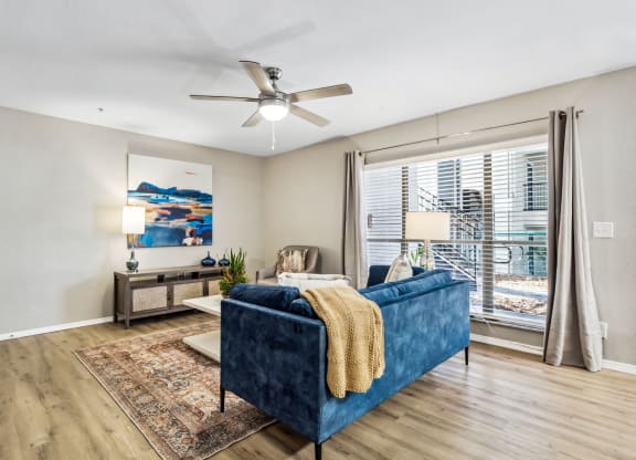 a living room with a blue couch and a ceiling fan at Reserve at Temple Terrace, Temple Terrace