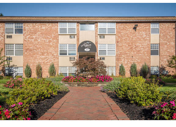 A brick building with a garden in front.