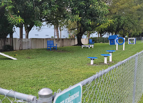 a park with benches and tables in the grass