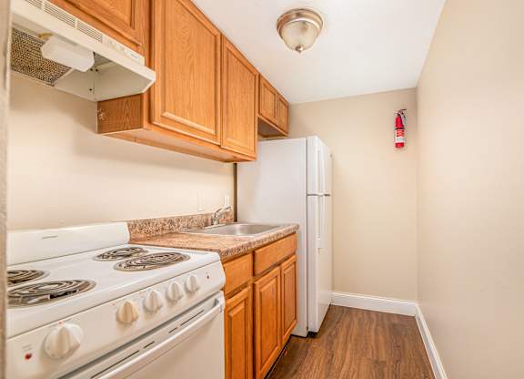 A kitchen with a white stove and a white refrigerator.