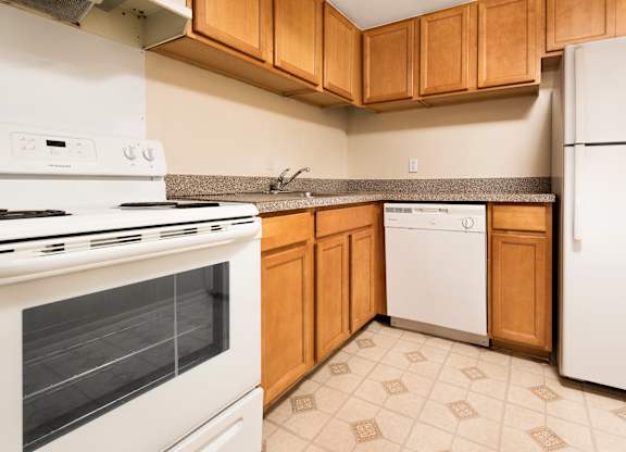 A kitchen with a white stove and white refrigerator.