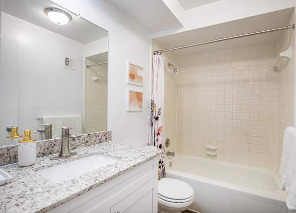 A white bathroom with a sink, toilet, and bathtub.