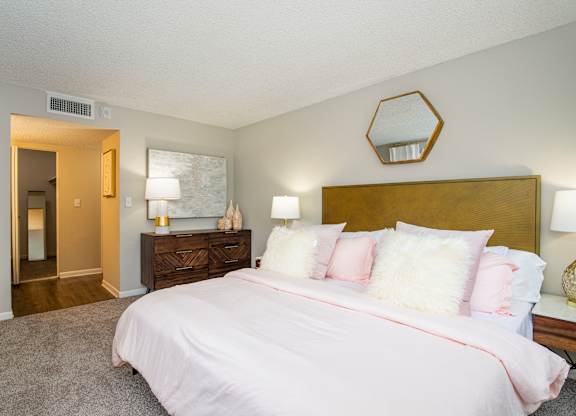 A bedroom with a bed, nightstand, and lamp.