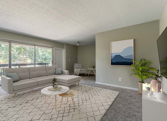 A living room with a grey sofa, a white coffee table, and a painting on the wall.