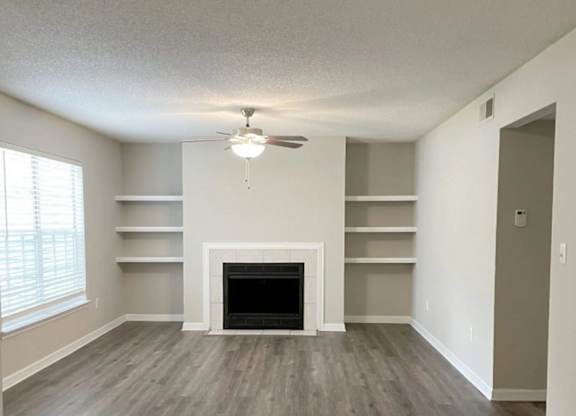 A room with a fireplace and shelves.