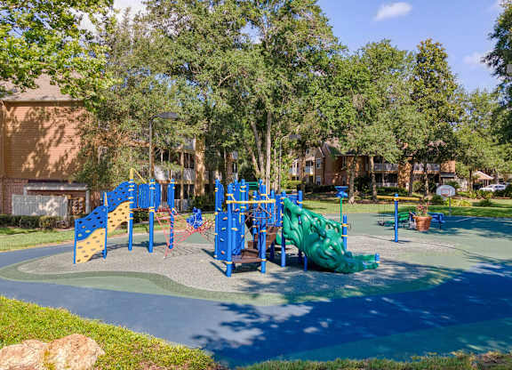 A playground with a blue slide and a green slide.