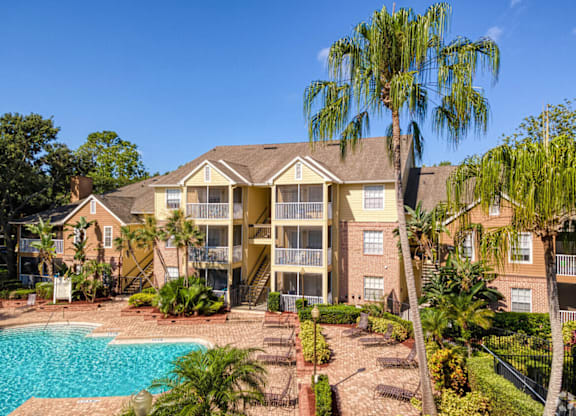 A large apartment complex with a pool in the foreground.