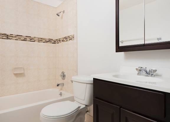 A white toilet sits next to a bathtub in a bathroom.