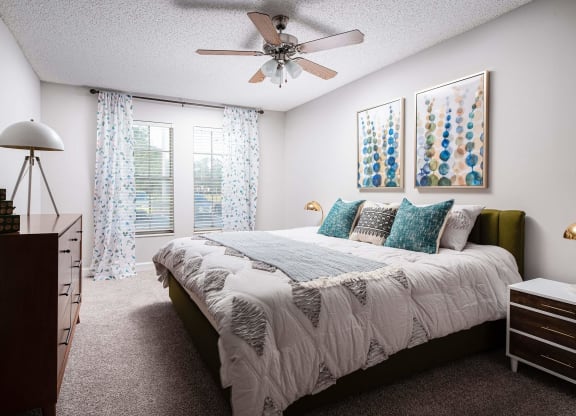 a bedroom with a bed and a ceiling fan  at The Park at Chesterfield Apartment Homes, Florida