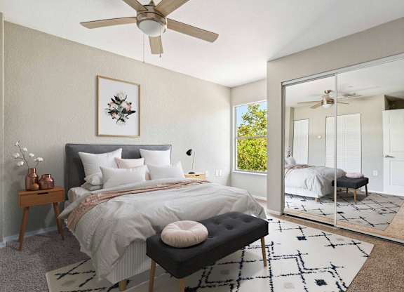 A bedroom with a large bed and a ceiling fan.