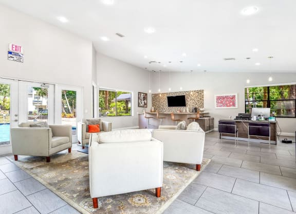 a living room with couches and chairs and a pool at Waterford Park Apartment Homes, LLC, Lauderhill