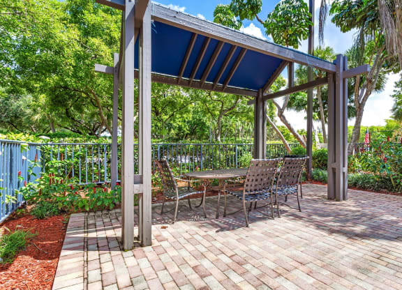 a patio with a picnic table and a pergola at Waterford Park Apartment Homes, LLC, Lauderhill, 33319